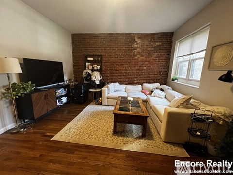 A living room with a white couch and a wooden coffee table.