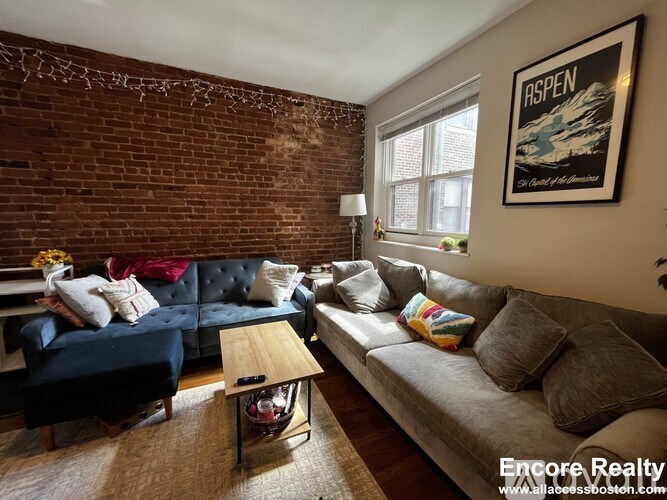 A living room with a blue couch and a coffee table.