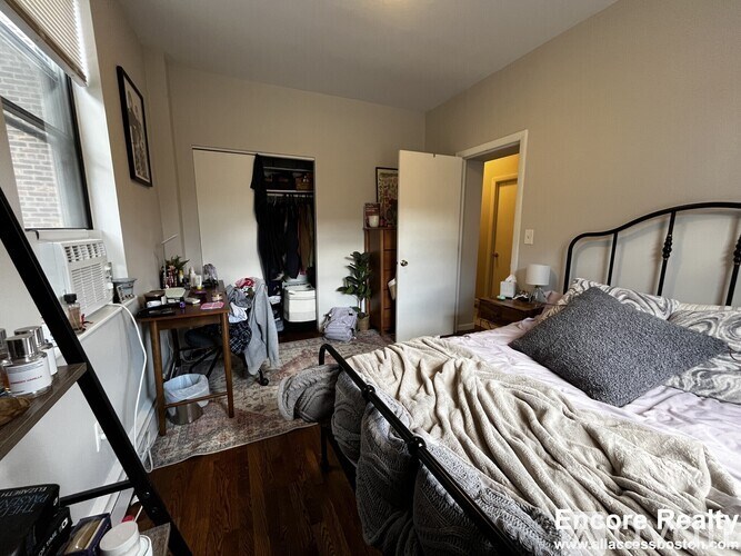 A bedroom with a bed, desk, and chair.
