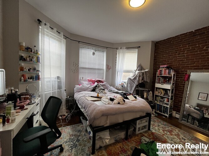 A bedroom with a bed, desk, and chair.