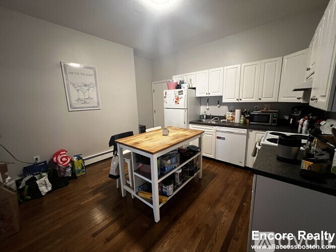 A kitchen with a wooden table and white cabinets.