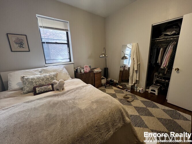 A bedroom with a large bed and a wardrobe.