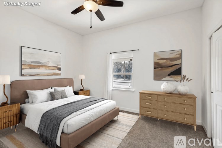 A bedroom with a large bed, a dresser, and a ceiling fan.