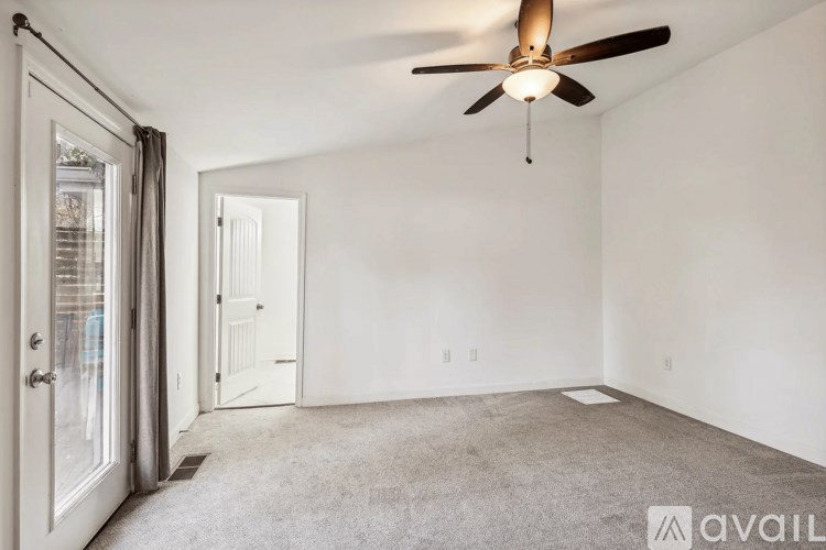 A room with a ceiling fan and carpeted floor.