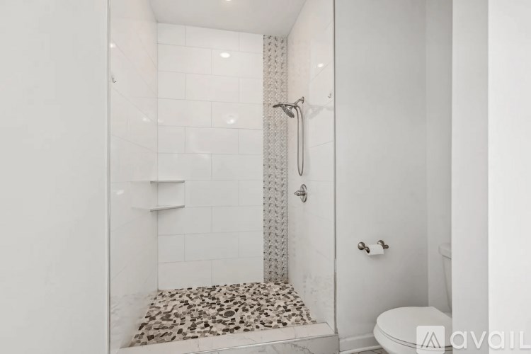 A white bathroom with a leopard print mat on the floor.