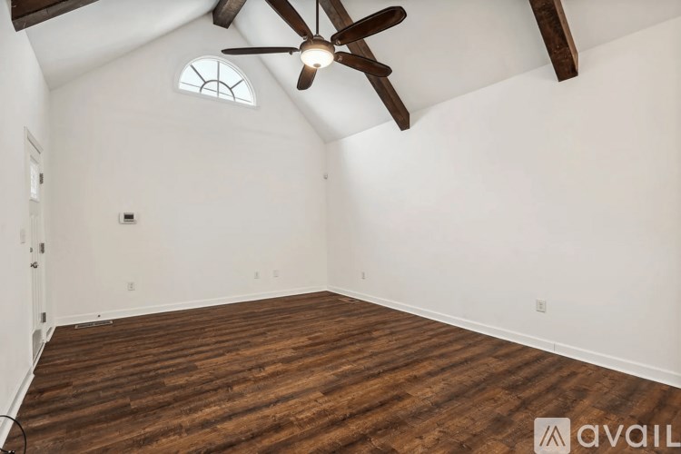 A room with wooden flooring and a ceiling fan.