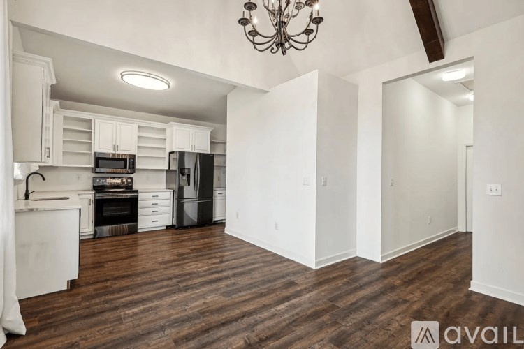 A kitchen with white cabinets and a wooden floor.