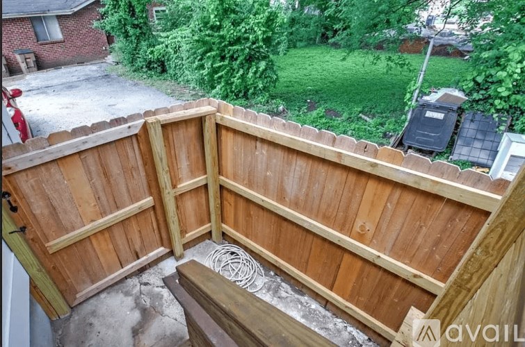 A wooden deck with a metal grate in the middle.