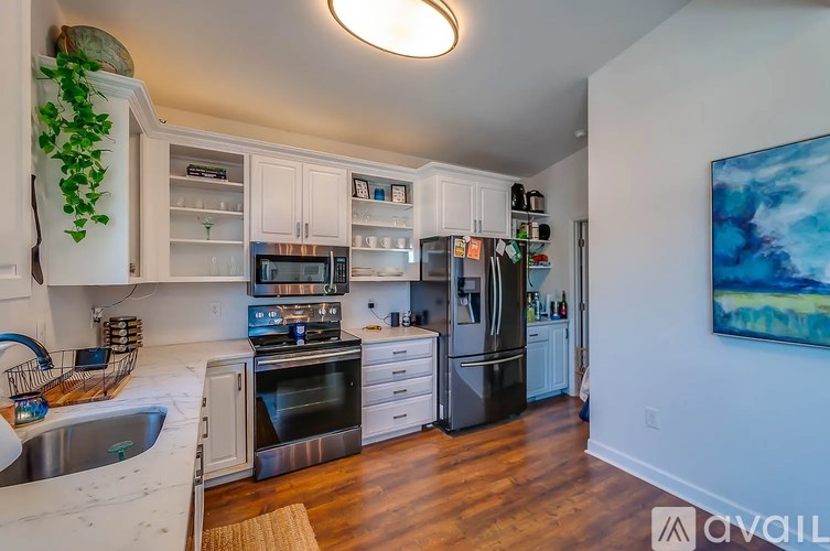 A kitchen with white cabinets and a stainless steel refrigerator.