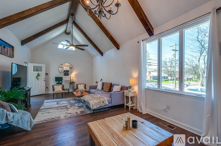 A living room with a wooden floor and a large window.
