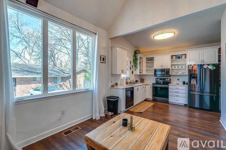 A kitchen with a wooden table in the middle of the room.