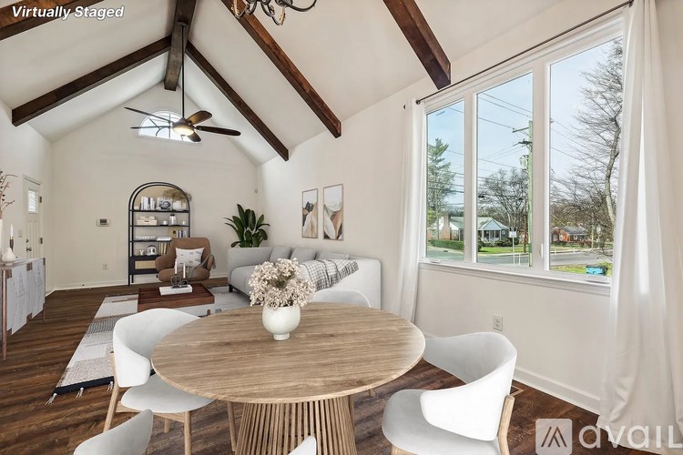 A dining room with a wooden table and white chairs.