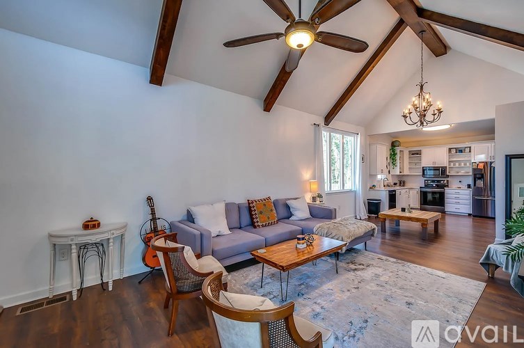 A living room with a blue couch and a guitar on the side table.