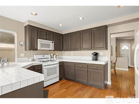 A kitchen with white and brown cabinets and appliances.