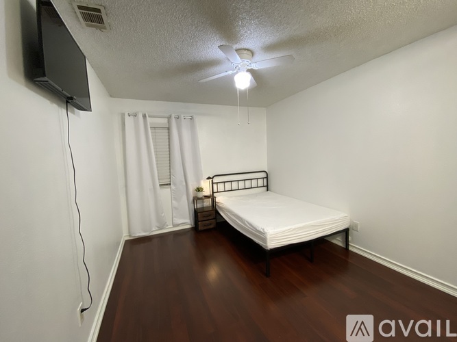 A bedroom with a large bed and a ceiling fan.
