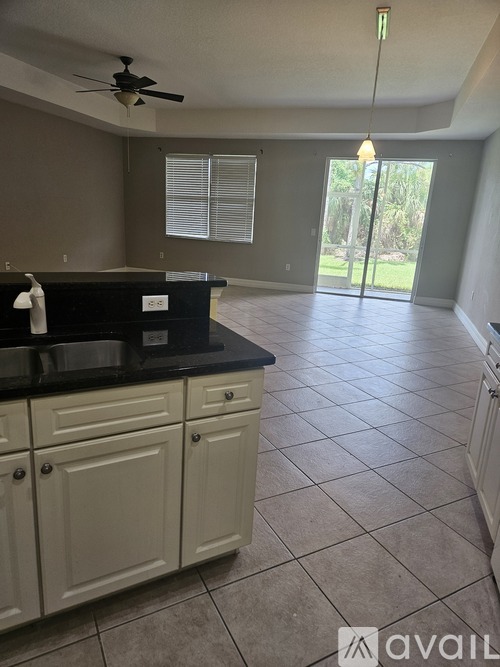 A kitchen with a black countertop and white cabinets.