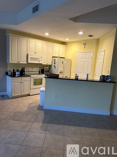 A kitchen with white cabinets and appliances.