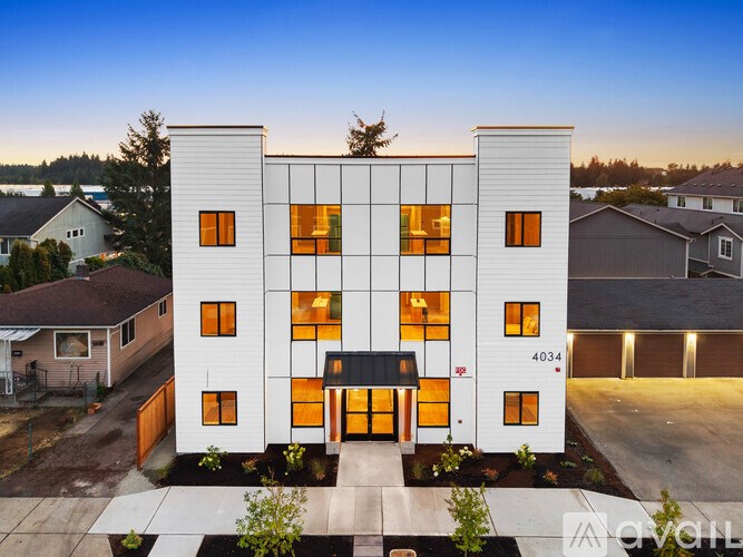A modern white building with orange windows and a black awning is labeled 4034.