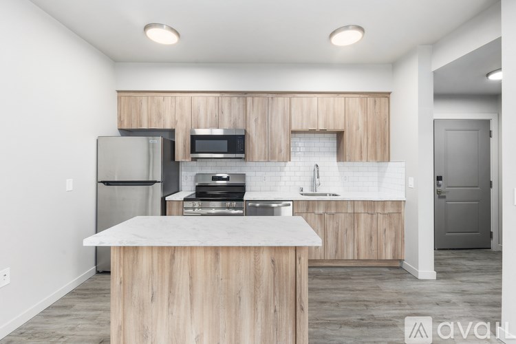 A kitchen with wooden cabinets and a marble countertop.