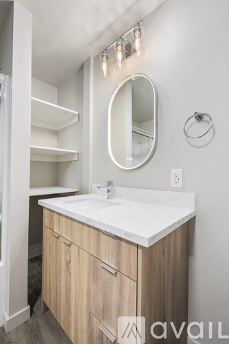 A bathroom with a sink, mirror, and lights.