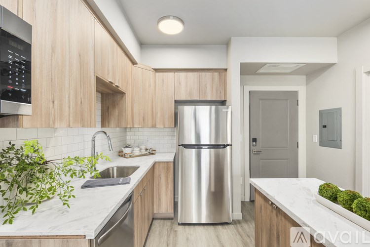 A modern kitchen with a stainless steel refrigerator and wooden cabinets.