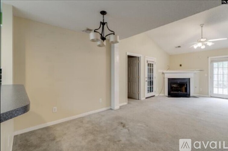 A living room with a fireplace and a chandelier.
