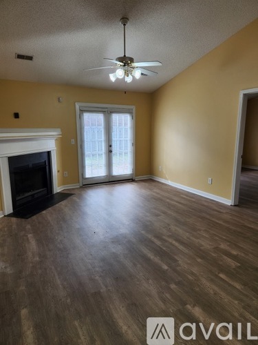 A kitchen with a black fridge and white tiled floor.