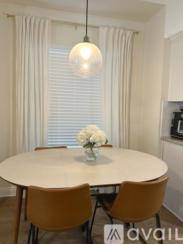 A dining room with a round table and chairs.