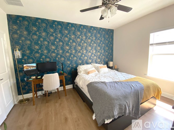 A bedroom with a bed, desk, and chair.