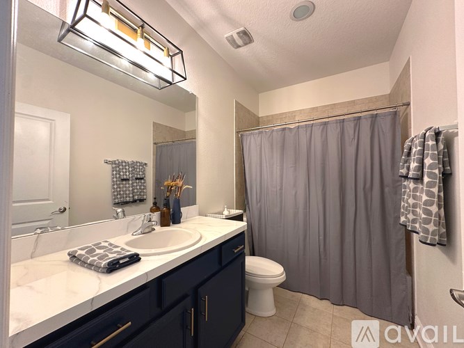 A bathroom with a sink, toilet, and shower.