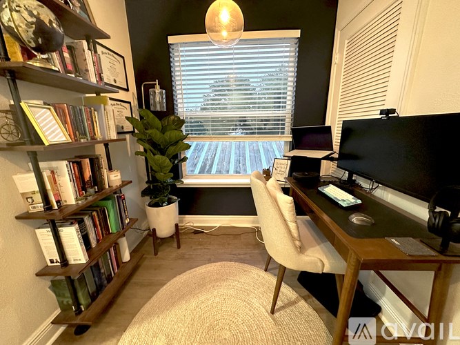 A room with a desk, chair, and bookshelf.