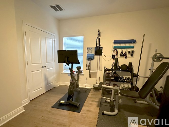 A home gym with a variety of equipment including a treadmill, stationary bike, and weight machines.