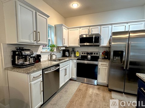 A kitchen with white cabinets and stainless steel appliances.
