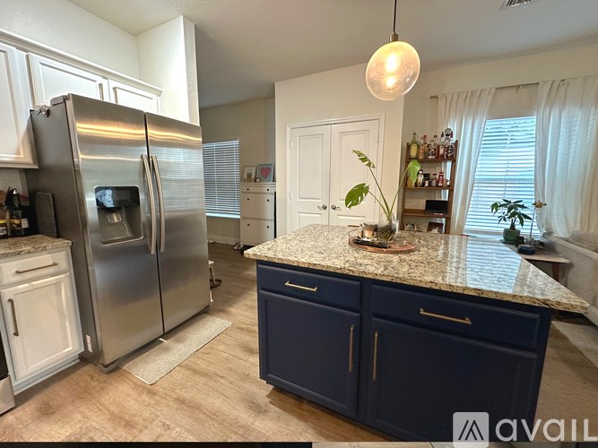 A kitchen with a granite countertop and a refrigerator.