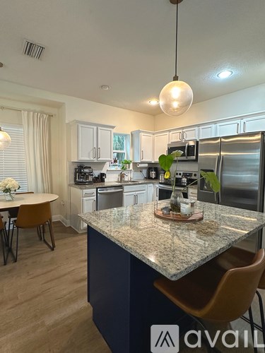 A kitchen with a granite countertop and a dining table with chairs.