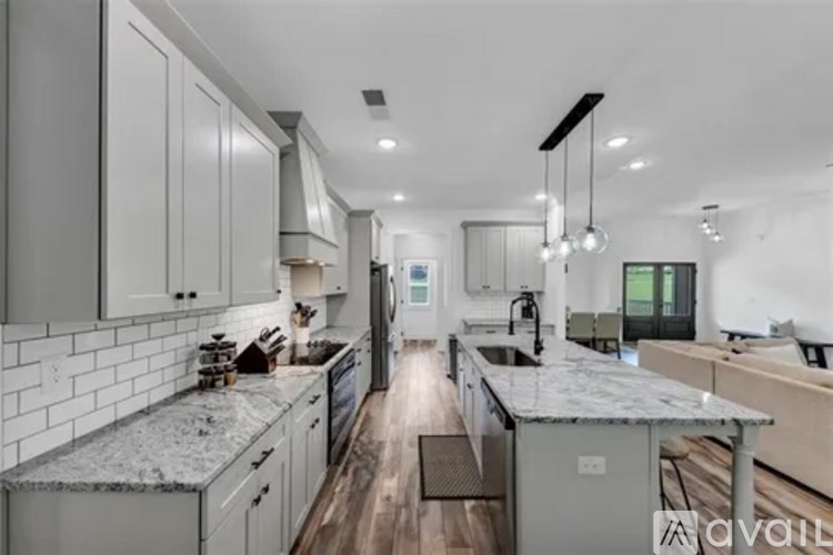 A modern kitchen with a marble countertop and stainless steel appliances.
