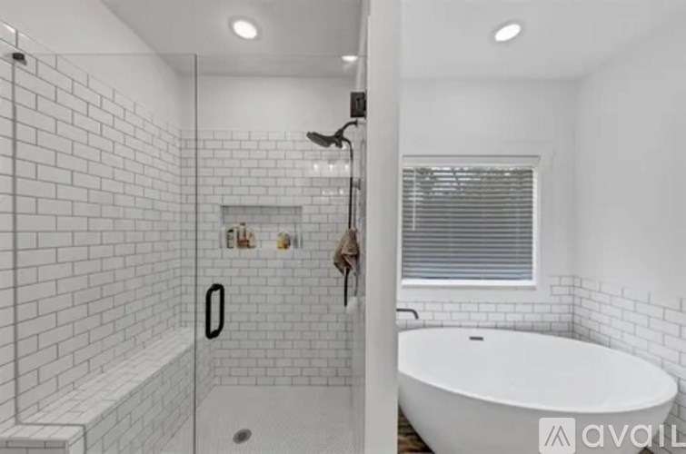 A white tiled bathroom with a bathtub and a walk-in shower.