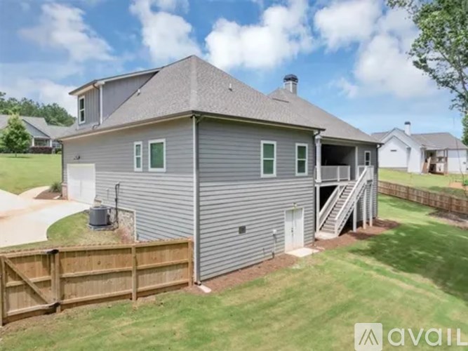 A house with a grey exterior and a wooden fence in front of it.