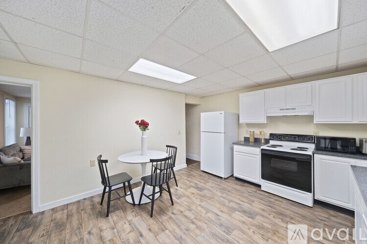A kitchen with a table and chairs and a vase of flowers.