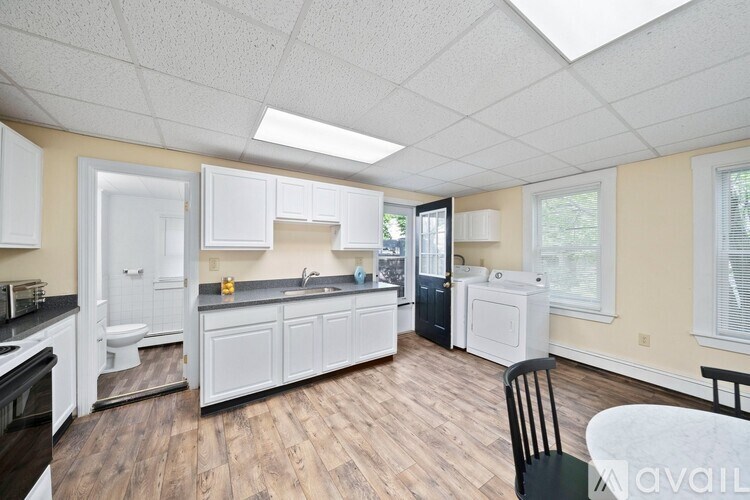 A kitchen with white cabinets and a wooden floor.