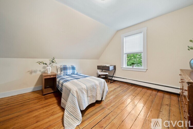 A bedroom with a bed and a window.