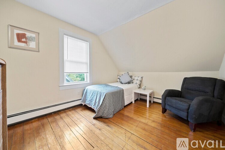 A room with a bed, a chair, and a table.