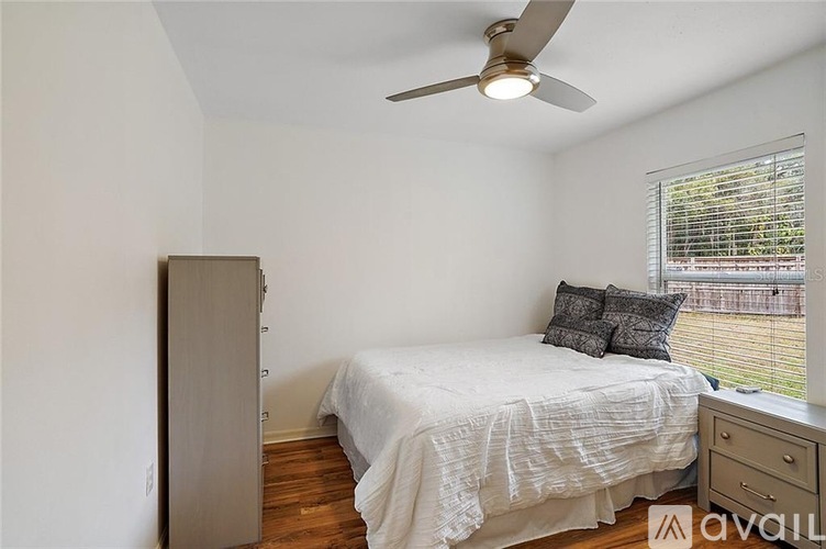 A room with a window covered by white blinds.