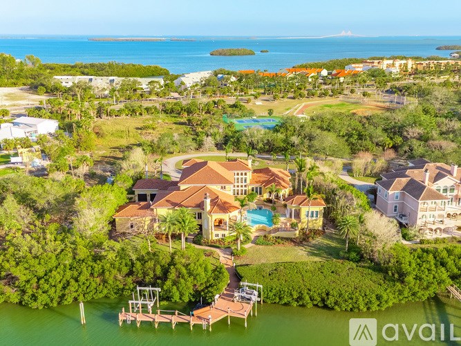 A bird's eye view of a house surrounded by greenery and a body of water.