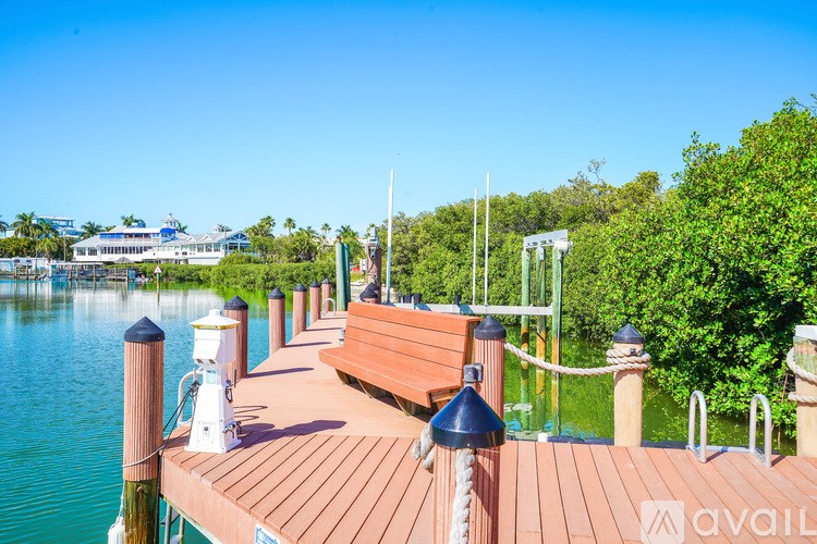 A wooden dock with benches and lampposts over a body of water.