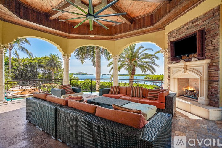 A large outdoor patio with a fireplace and a view of the ocean.