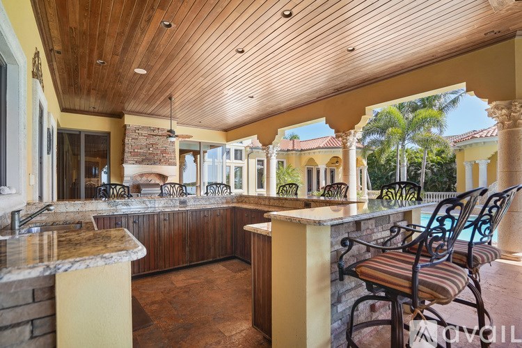 A kitchen with a bar area and a striped chair.