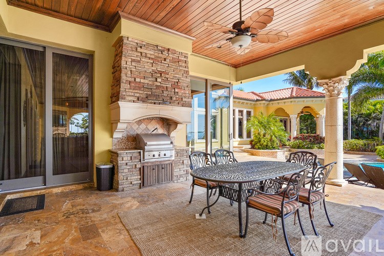 A patio with a table and chairs and a fireplace.