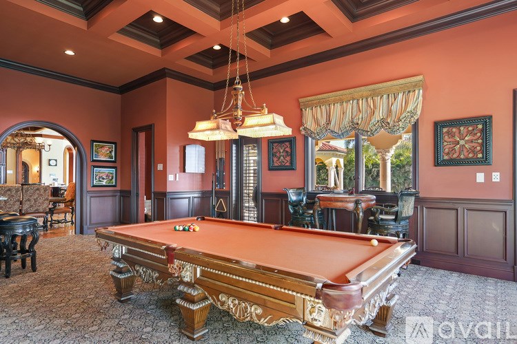 A pool table is in the middle of a room with a mirror on the wall.