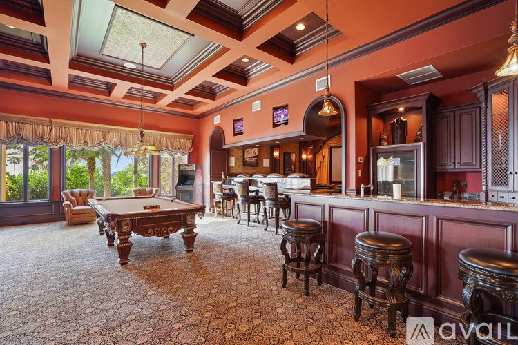 A room with a pool table and bar area.